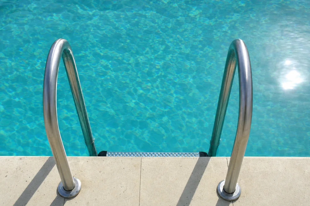 Edelstahlleiter führt in einen klaren Salzwasserpool