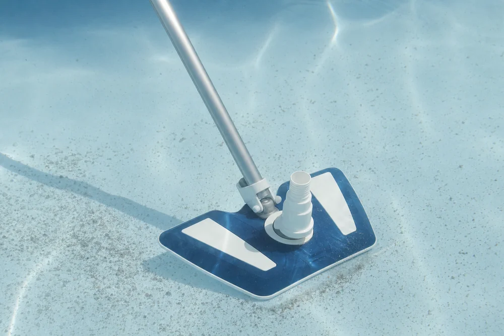 Bodensauger entfernt abgesetzte Flocken vom Beckenboden eines Pools