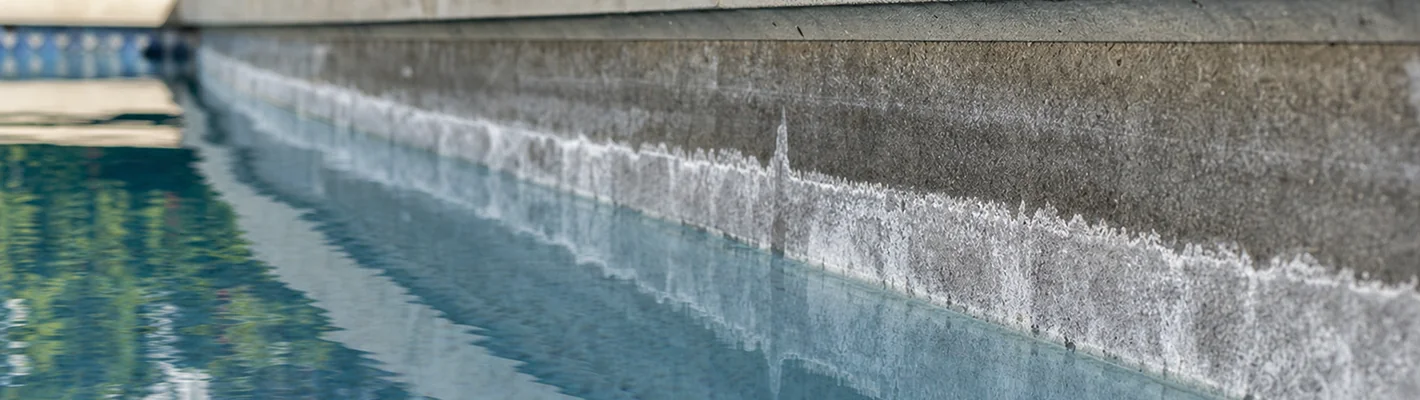 Weiße Kalkablagerungen am Beckenrand eines Pools