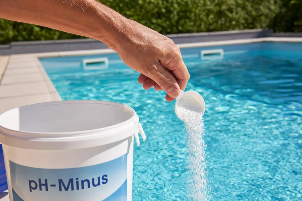 pH-Minus Granulat wird zur Senkung des pH-Werts ins Poolwasser gegeben