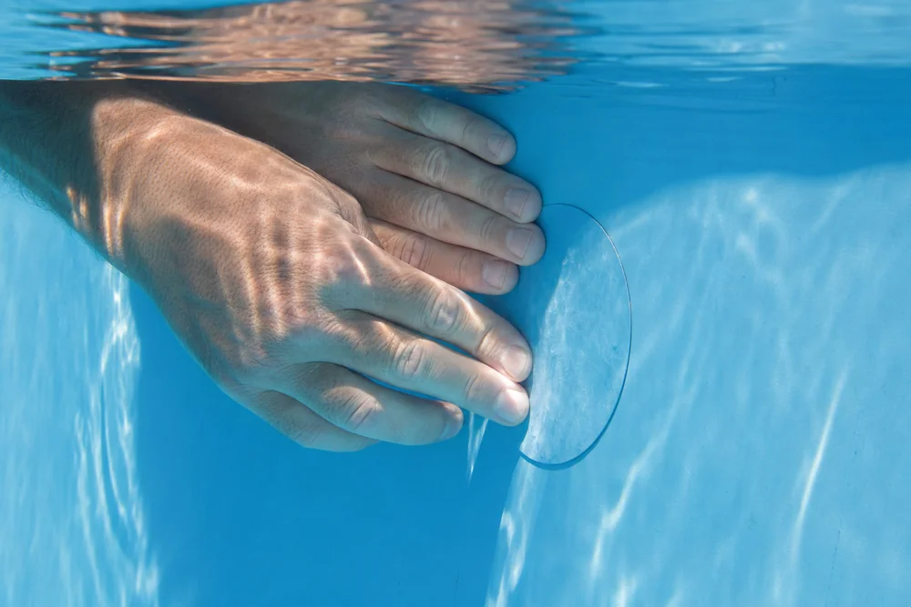 Setzen eines Folienflickens unter Wasser am Pool