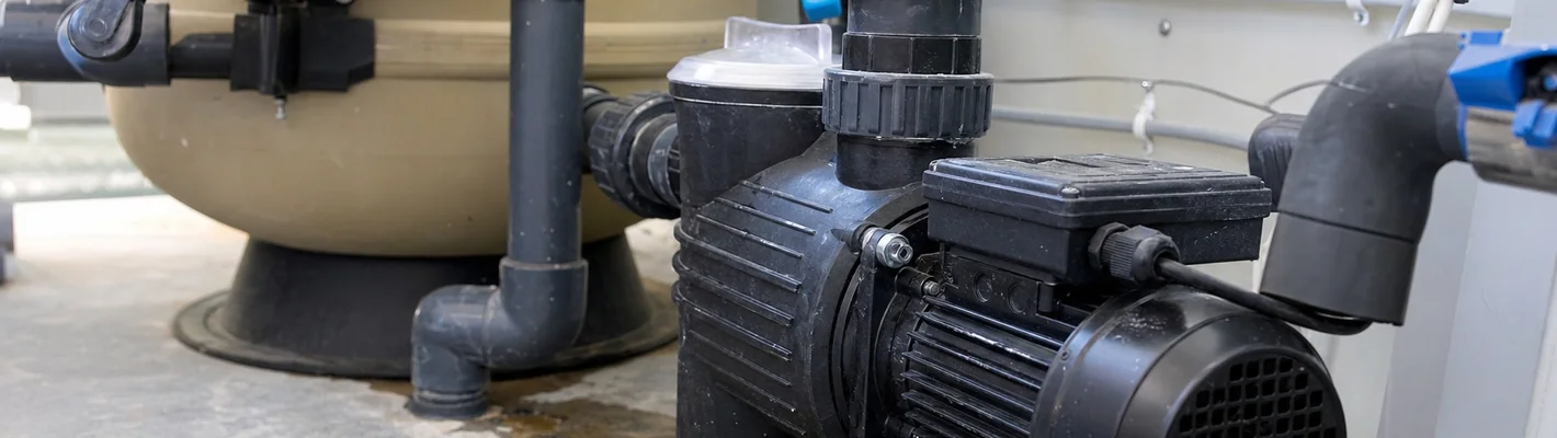 Poolpumpe im Technikraum mit Wasserpfuetze unter dem Motor