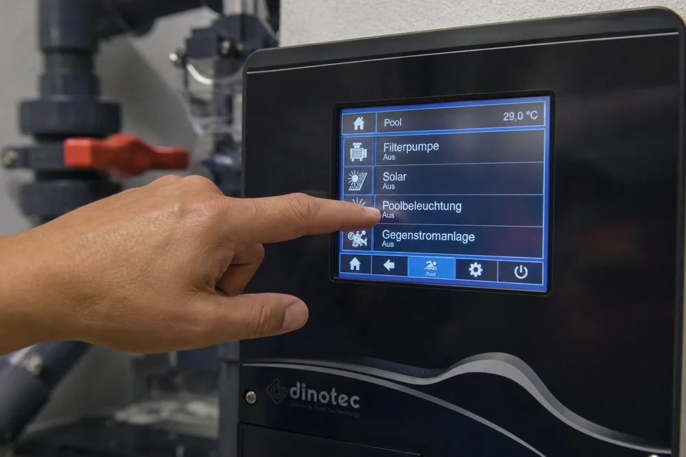 Person bedient das Touch-Display einer modernen Poolsteuerung Person bedient das Touch-Display einer modernen Poolsteuerung