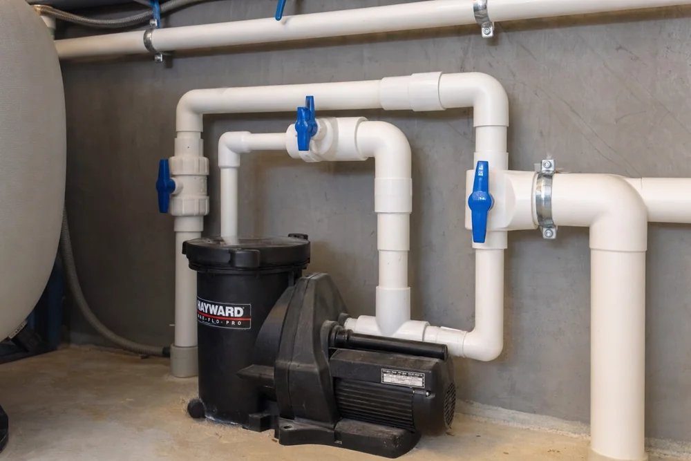 Sauber verklebte PVC-Verrohrung mit Kugelhähnen an einer Poolpumpe