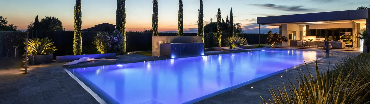 Pool bei Dämmerung mit farbwechselnder RGB-Unterwasserbeleuchtung