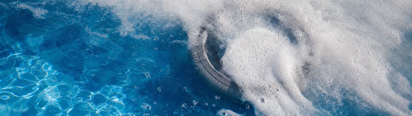Schaum auf der Wasseroberfläche eines Pools an einer Einlaufdüse
