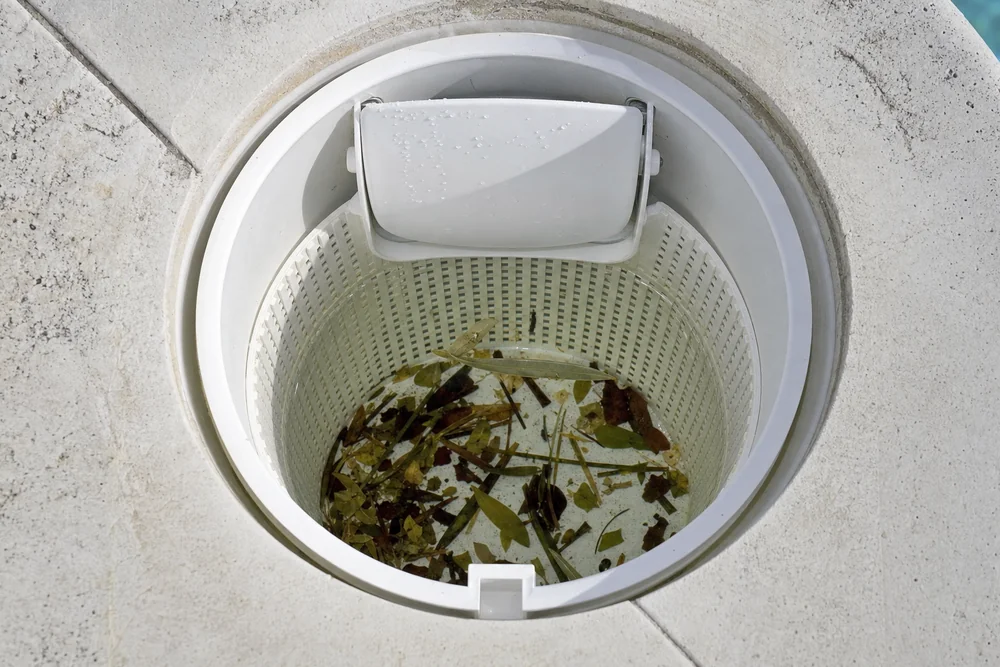 Blick in einen geöffneten Pool-Skimmer mit Vorfilterkorb und Klappe Blick in einen geöffneten Pool-Skimmer mit Vorfilterkorb und Klappe