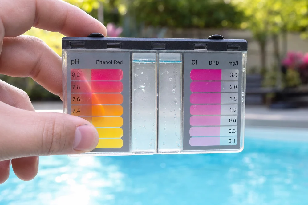 Wassertest mit Farbskala vor einem Pool
