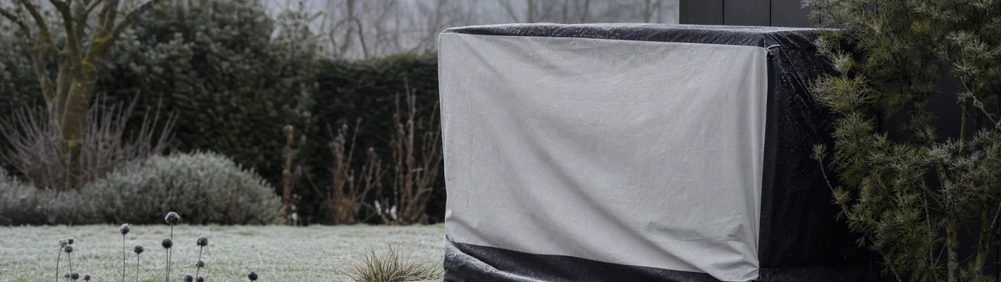 Abgedeckte Pool-Wärmepumpe im winterlichen Garten