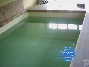Hallenbad mit grüner Folieauskleidung, gefüllt mit Wasser, Spiegelung eines Fensters im Wasser
