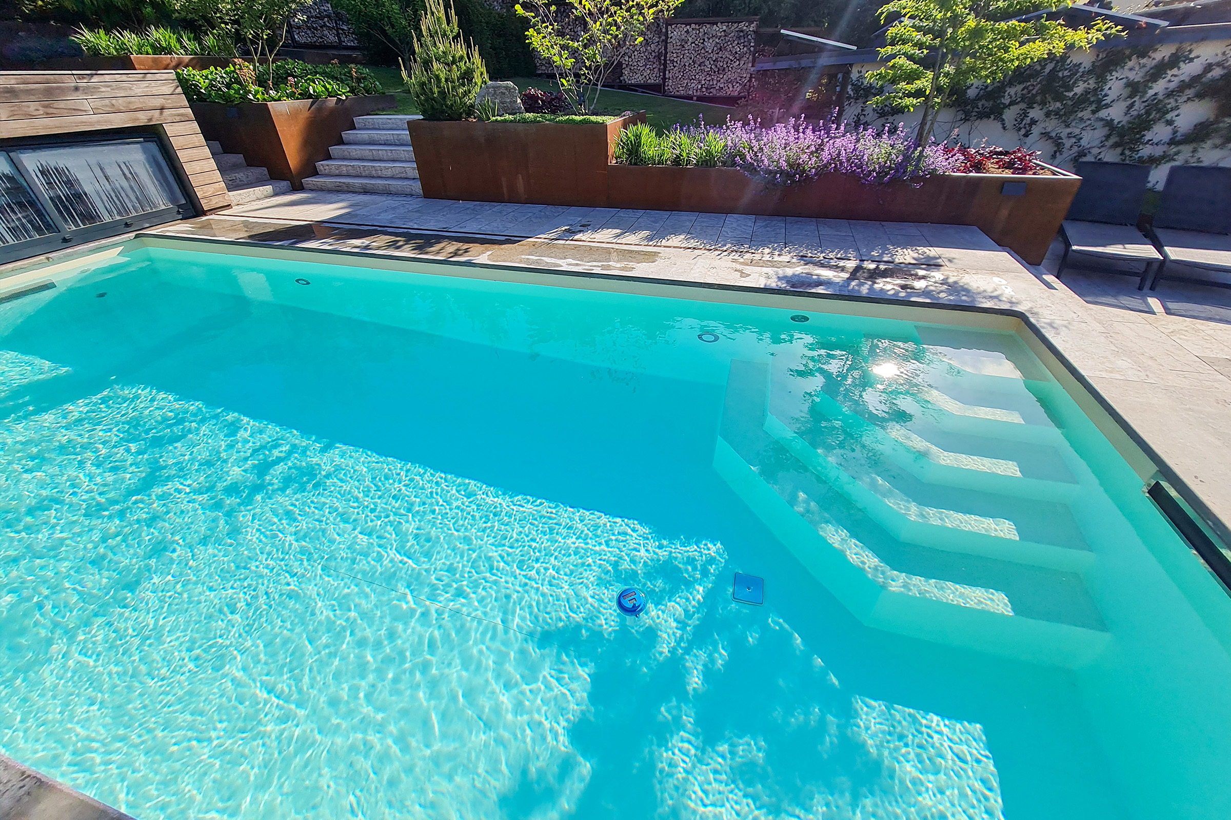 Sicht auf das Poolbecken mit weichen Wasserreflexionen und farblich abgestimmter Umgebung