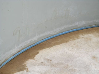 Detailansicht des blauen Keils, der die Poolfolie am Boden eines Stahlwandbeckens fixiert