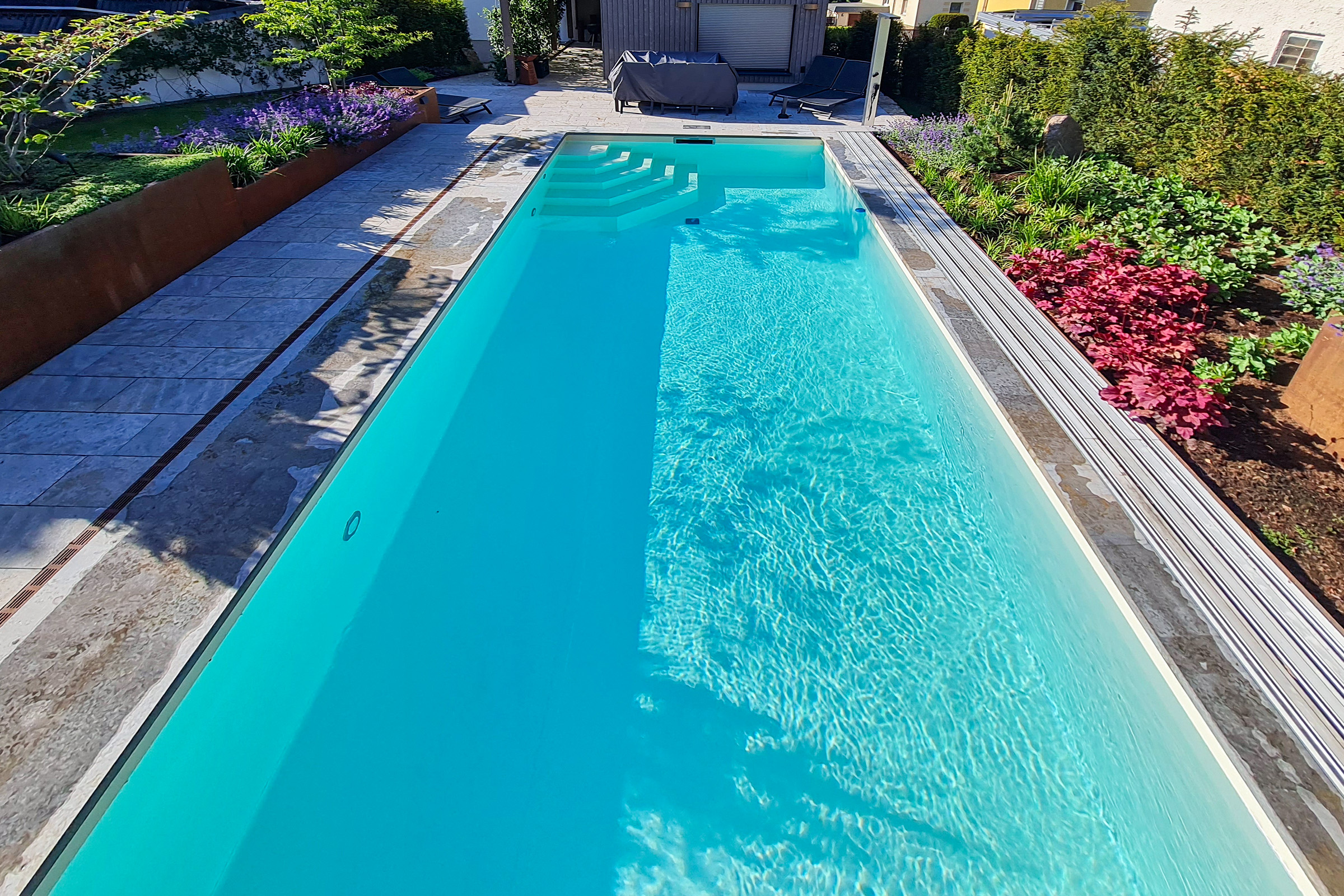 Flacher Pool mit beiger Folienauskleidung in elegant strukturierter Gartenumgebung