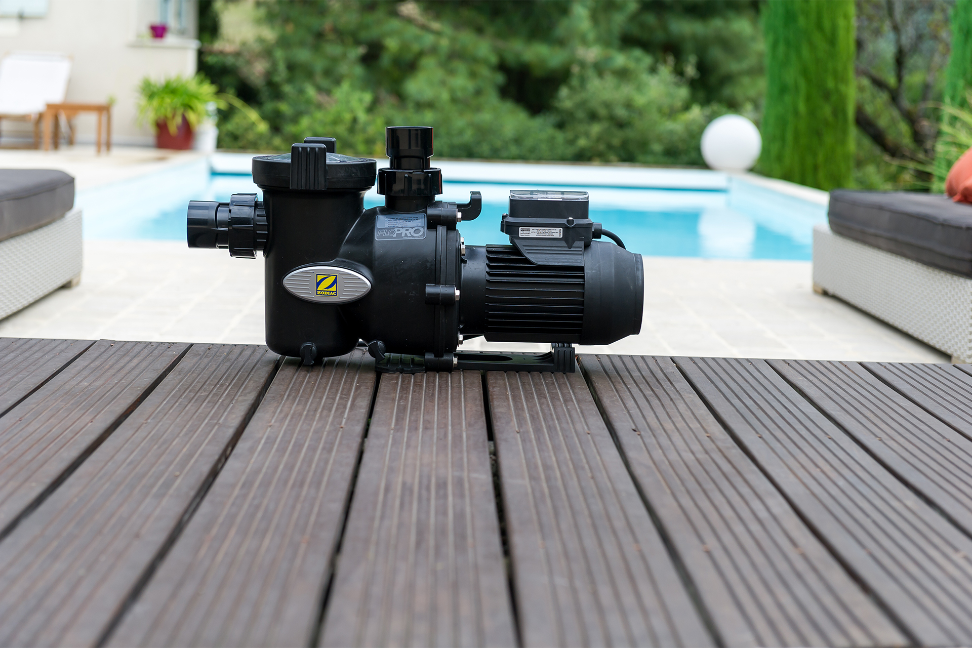 Zodiac FloPro Poolpumpe auf einer Holzterrasse vor einem Pool
