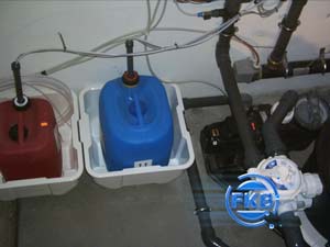 Dosieranlage mit blauen und roten Kanistern für Poolchemie im Technikraum eines Hallenbades