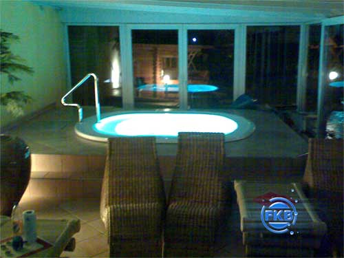 Beleuchteter Whirlpool-SPA MANDURA mit Einstiegsleiter und Sitzgelegenheiten in einem Innenbereich