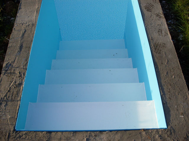 Einstiegstreppe eines Freiformbeckens mit blauer Folie und weißer Treppenfolie
