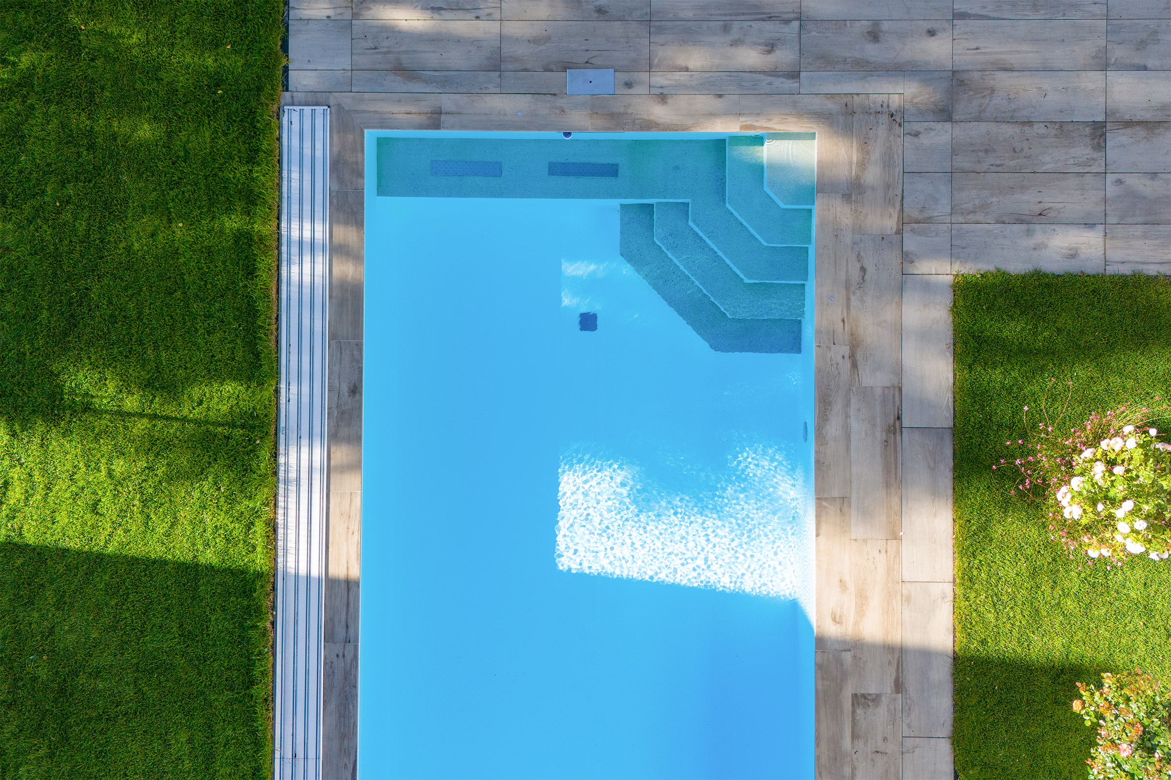 Betonpool mit Luftsprudelsitzbank und Poolüberdachung