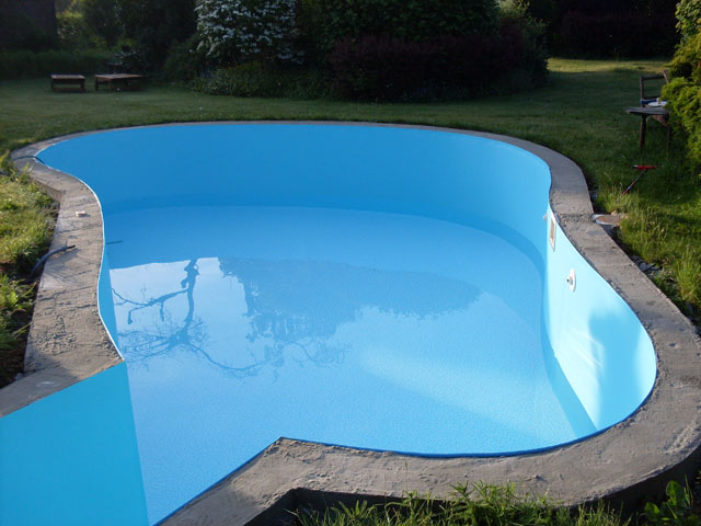 Freiformbecken mit blauer Folie und integrierter Treppe, umgeben von einer Betonumrandung und Rasen