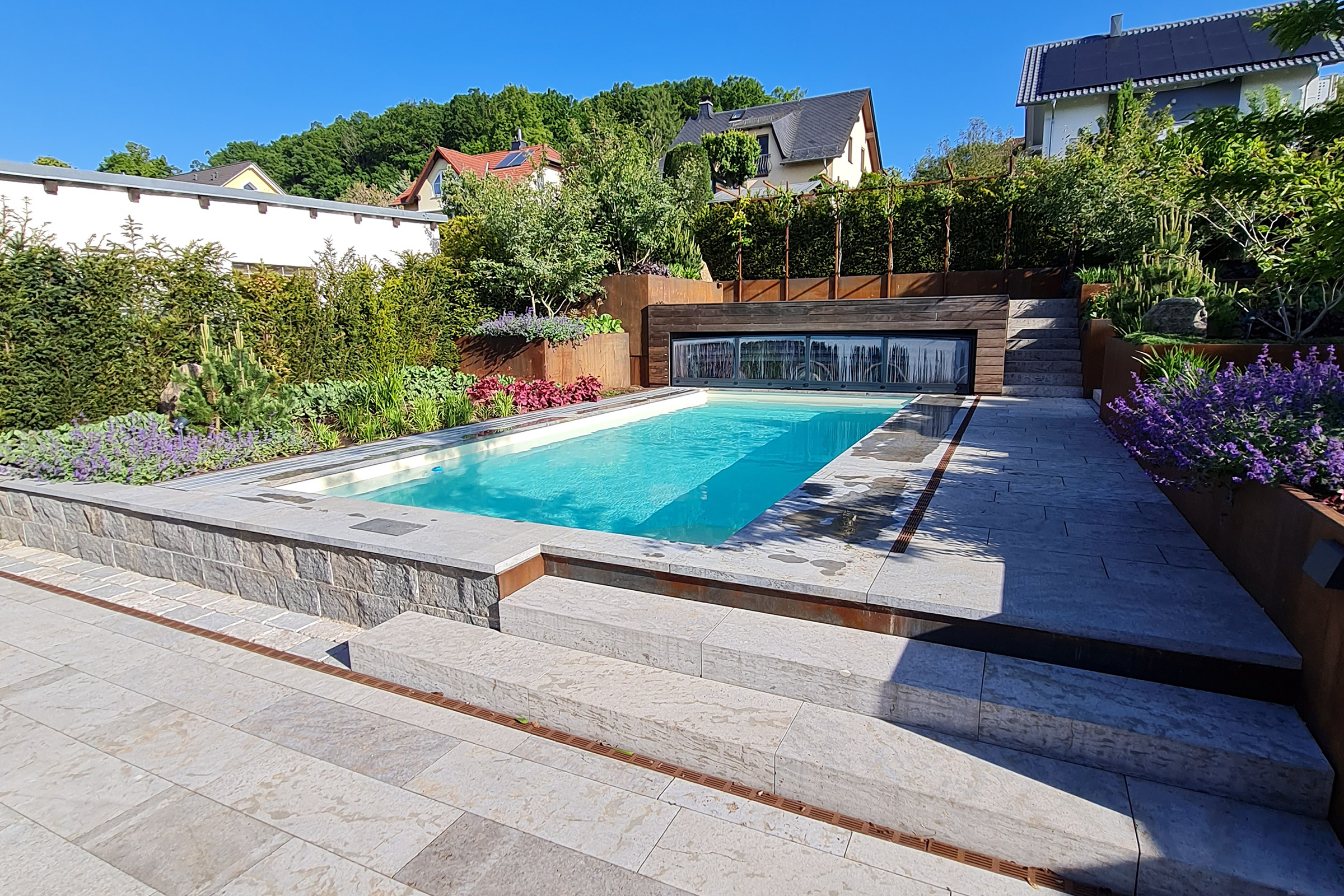 Moderner Massivpool mit heller Folienauskleidung und Natursteinumrandung in stilvoller Gartenanlage