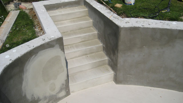 Betontreppe eines Freiformbeckens vor der Folienverkleidung, mit angrenzenden Beckenwänden