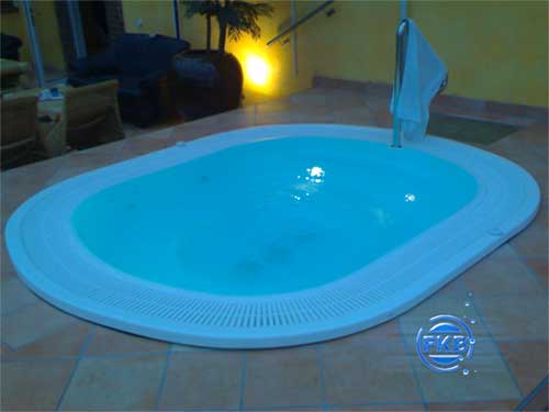 Ovaler Whirlpool-SPA MANDURA mit blauem Wasser und umlaufendem Gitterrost am Beckenrand